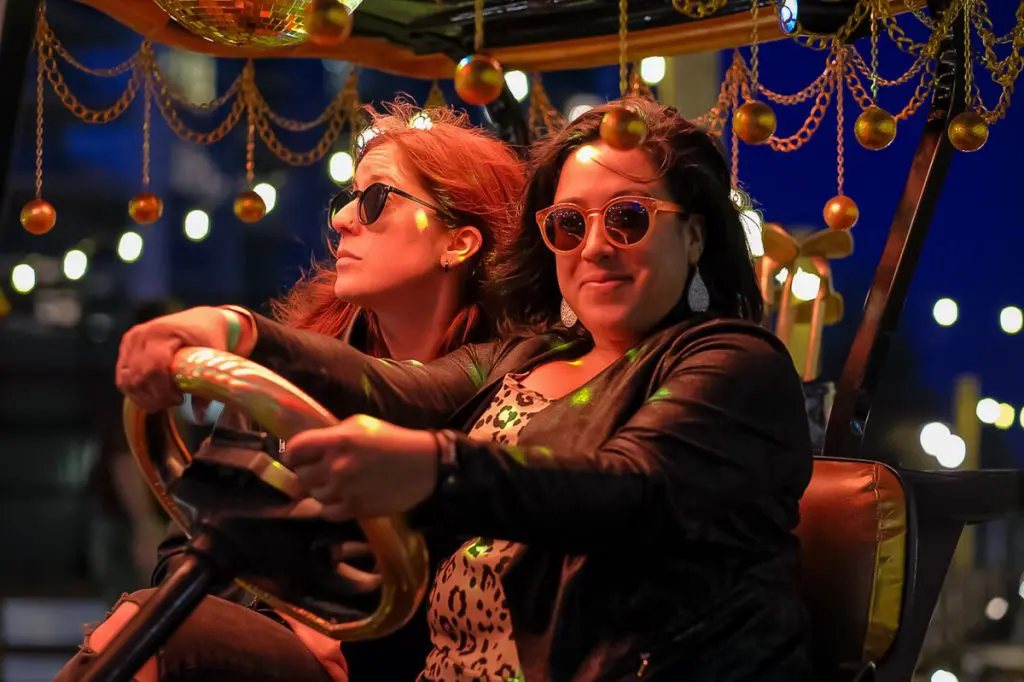 Guests enjoy a carnival-style ride during a nighttime corporate celebration with festive lights in the Bay Area.