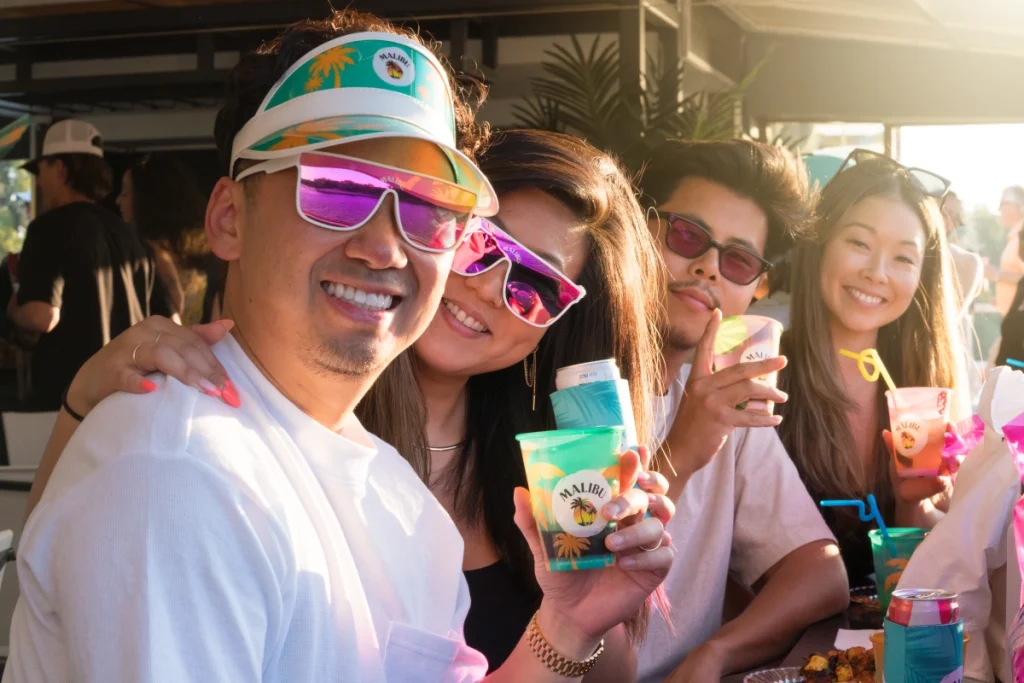 Attendees smile and pose with branded beverages during a fun outdoor corporate activation in San Francisco.