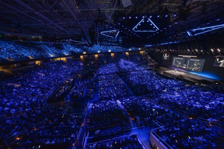 Large-scale corporate event production at San Francisco Bay Area arena venue with thousands of attendees and full stage lighting.